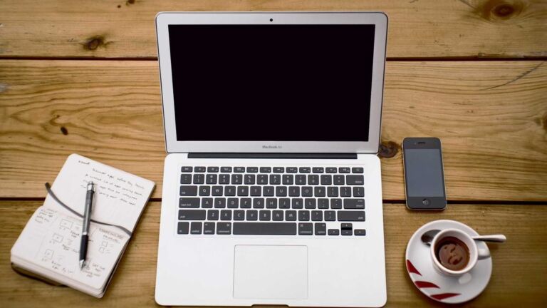Laptop, phone and coffee on a desk